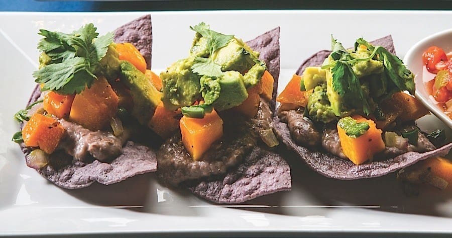 A plate of food with tortilla chips and vegetables.