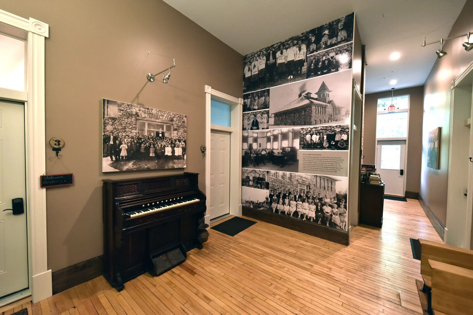 A piano in the middle of a room with a wall mural.