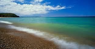 A beach with waves coming in from the ocean.