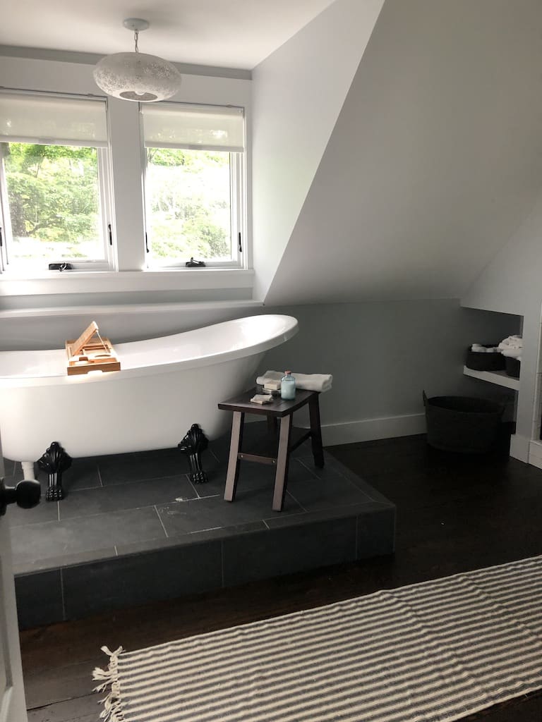 A bathroom with a tub and stool in it